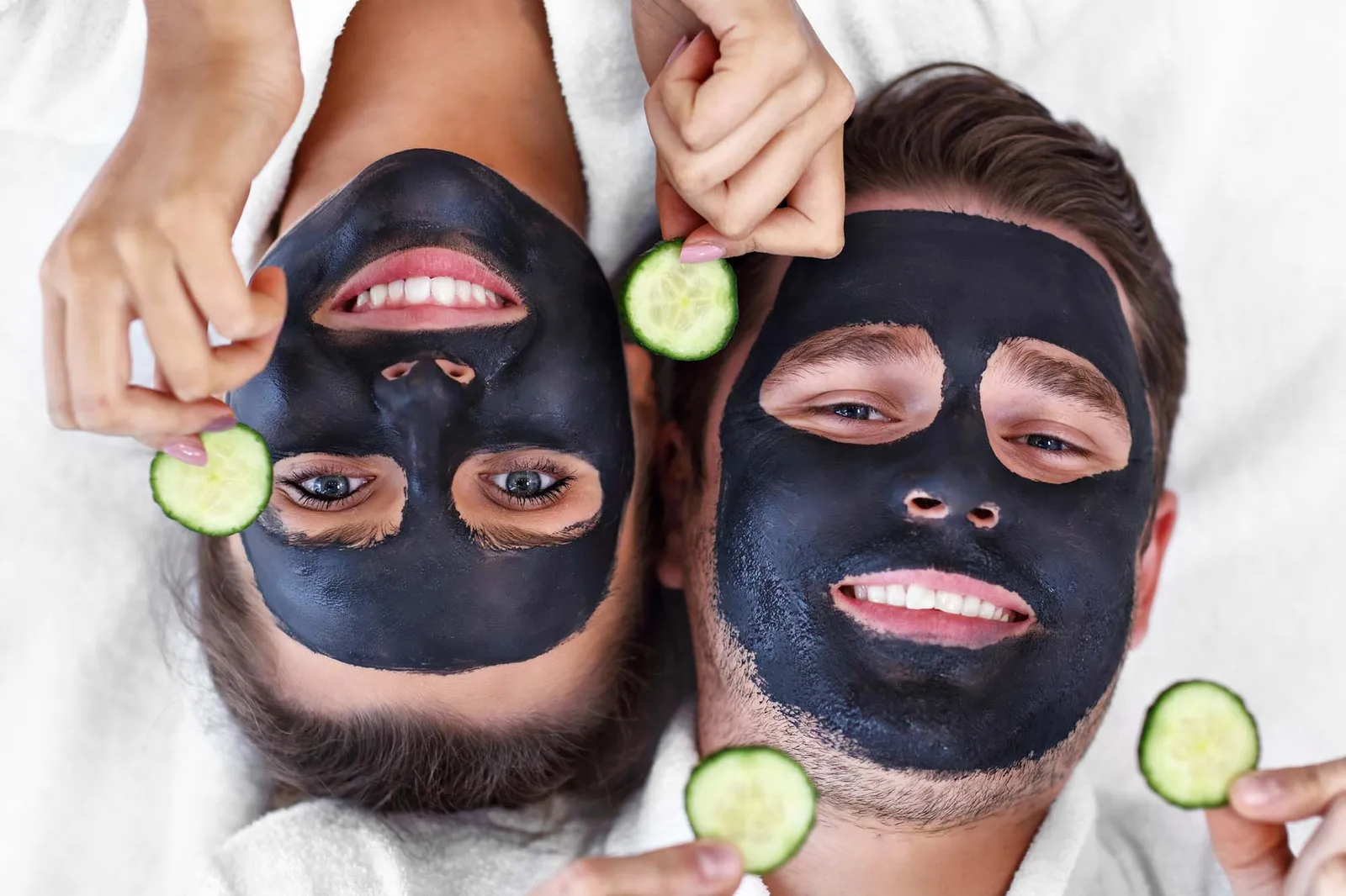 Happy couple having facial in spa salon