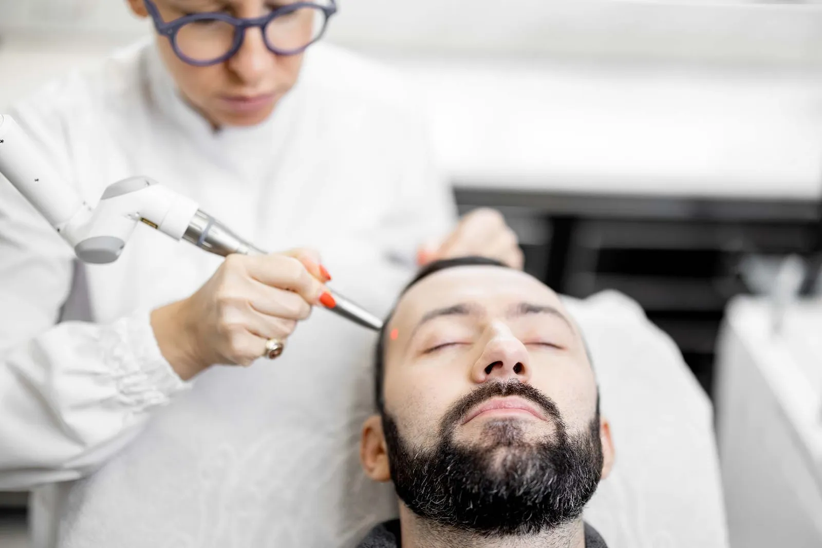 Cosmetologist doing laser facelifting procedure in beauty clinic